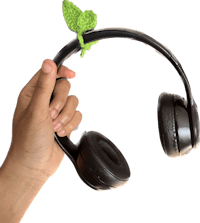a hand holding a pair of headphones with a leaf on it